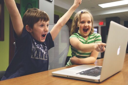 A happy boy and girl in front of a computer